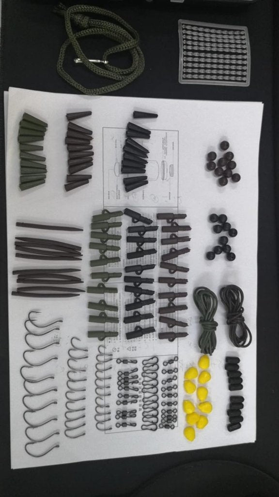 Laad afbeelding in Galerijviewer, Verschillende onderdelen zoals staven, koorden en kralen, gerangschikt op een raster op een witte achtergrond, lijken op een vakkundige opstelling uit de Onmisbare vishaken-kit voor elke vissessie!.
