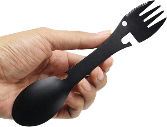 Een hand omvat een strakke zwarte spork van roestvrij staal, met aan de ene kant een lepel en aan de andere kant een gekartelde vork - ideaal voor jouw behoeften met 
