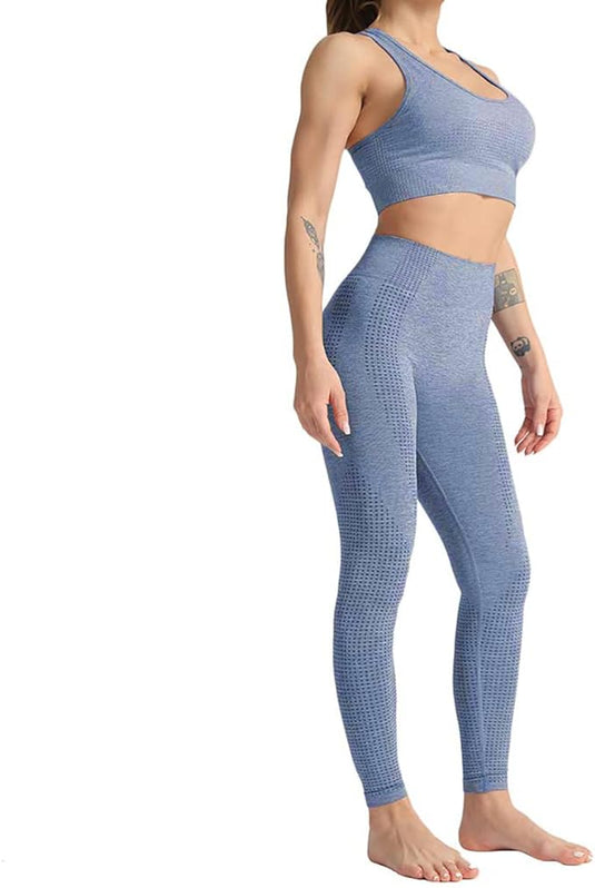 Een persoon in een blauwe yoga workoutset uit de "Zie er geweldig uit en voel je geweldig in deze 3-delige yoga workoutset!" staat op blote voeten en onthult tatoeages op hun linkerarm en pols.