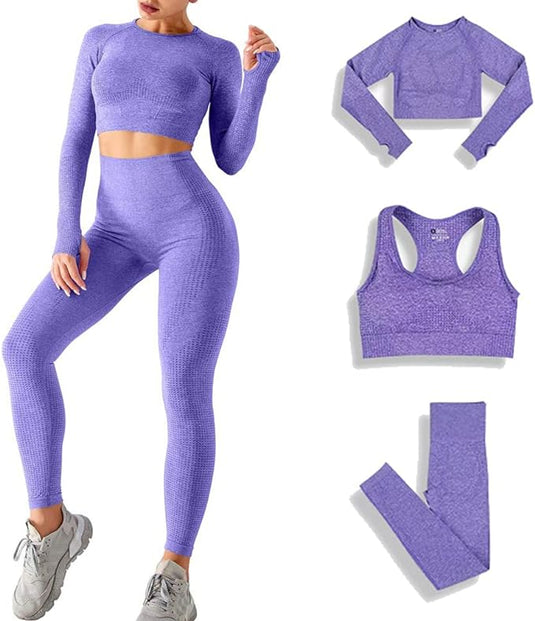 Een vrouw draagt de "Zie er geweldig uit en voel je geweldig in deze 3-delige yoga workoutset!" in het paars, inclusief een top met lange mouwen en naadloze leggings. In de buurt liggen ademende stoffen stukken: een sportbeha, top en leggings. Haar ensemble is afgemaakt met grijze sneakers.