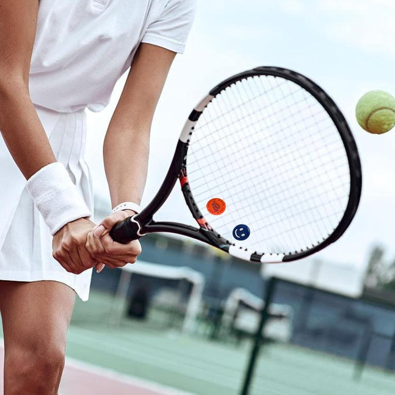 Laad afbeelding in Galerijviewer, De speler draagt een witte tennisuitrusting en gebruikt onze &quot;Verbeter jouw spel met onze grappige tennisdempers!&quot; voor optimale schokabsorptie, zodat hij de inkomende bal op de buitenbaan vakkundig kan slaan.
