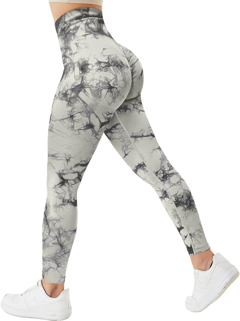 Load image into Gallery viewer, Een persoon in de &quot;Ervaar ultiem comfort en stijl met onze compressie sportlegging!&quot; met een marmerpatroon en een geplooid billenontwerp, gecombineerd met witte sneakers, gezien vanaf de zijkant.
