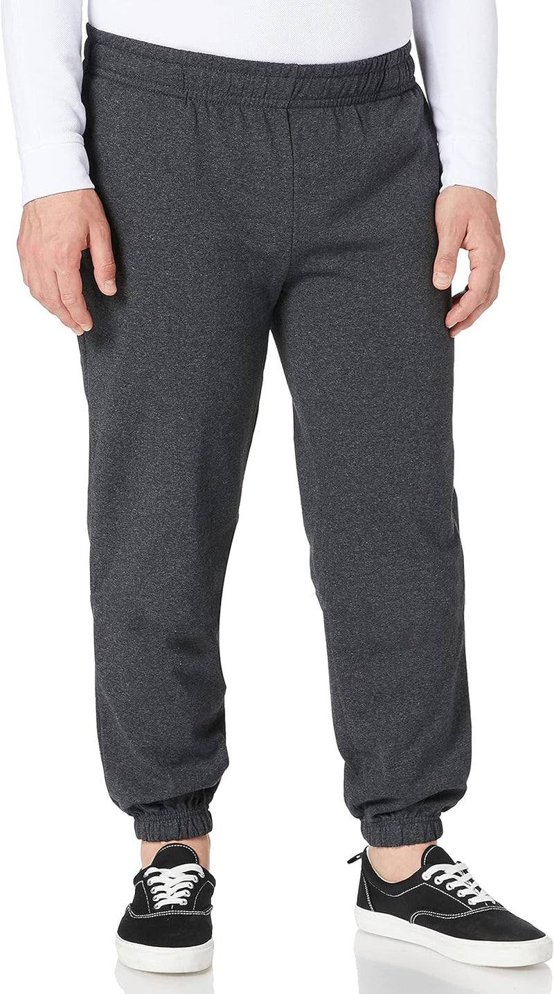 Laad afbeelding in Galerijviewer, Een persoon die de &quot;🏃‍♂️ Comfort, stijl en bewegingsvrijheid – De ultieme basic joggingbroek!&quot; in een donkergrijze tint, gecombineerd met zwarte sneakers met witte zolen, staat tegen een witte achtergrond.
