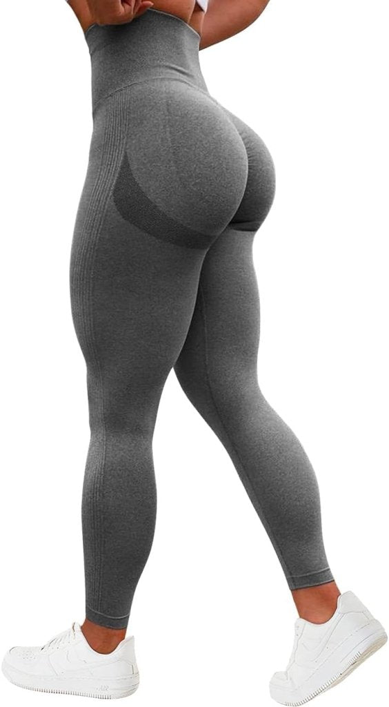 Load image into Gallery viewer, Een persoon draagt de compressie sportlegging met een geplooide billenontwerp en witte sneakers, staand op een effen witte achtergrond.
