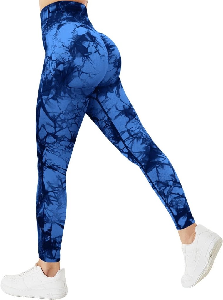 Load image into Gallery viewer, Een persoon modelleert de &quot;Ervaar ultiem comfort en stijl met onze compressie sportlegging!&quot; in hoog getailleerde blauwe tie-dye met een geplooid billenontwerp, gecombineerd met witte sneakers, side-poserend tegen een effen achtergrond.
