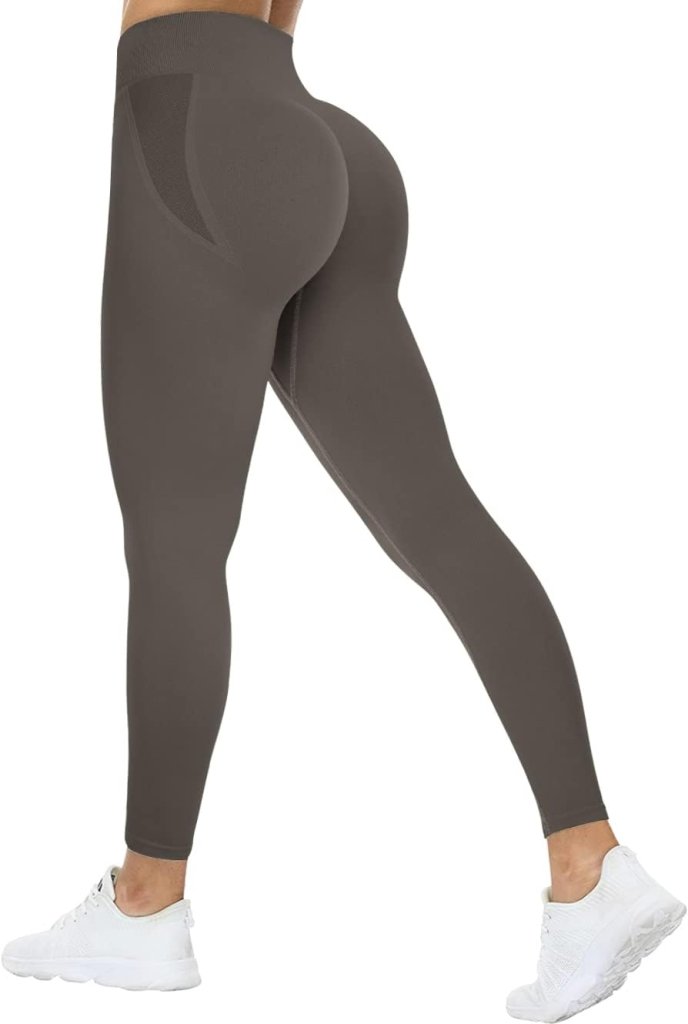 Load image into Gallery viewer, Persoon in grijze compressie sportlegging met witte sneakers, zijaanzicht. De legging heeft een hoge taille voor ondersteuning en comfort en een geplooid billenontwerp dat de rondingen benadrukt. Ontdek ultiem comfort en stijl met onze Ervaar ultiem comfort en stijl met onze compressie sportlegging!.
