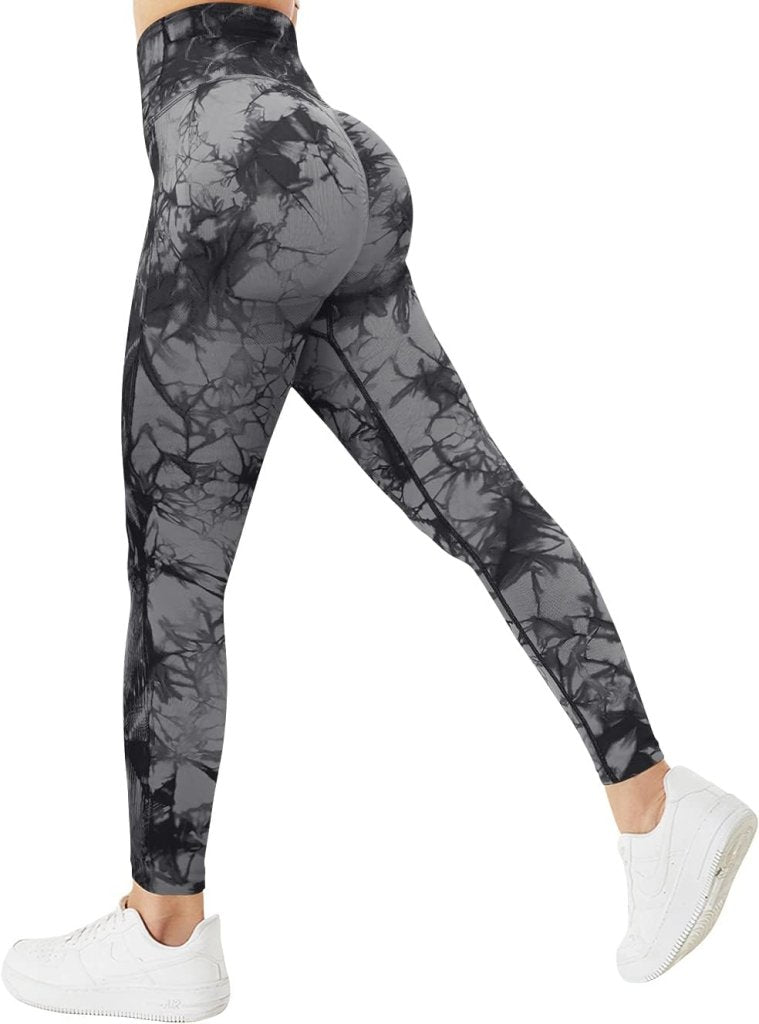 Load image into Gallery viewer, Van achteren gezien draagt een persoon de Ervaar ultiem comfort en stijl compressie sportlegging in grijze en zwarte tie-dye met witte sneakers.
