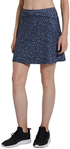 Laad afbeelding in Galerijviewer, Een vrouw staat tegen een effen achtergrond en combineert zwarte sneakers met een &quot;Sportieve en stijlvolle golfskort voor dames&quot; met blauw patroon, gemaakt van beperkt materiaal.
