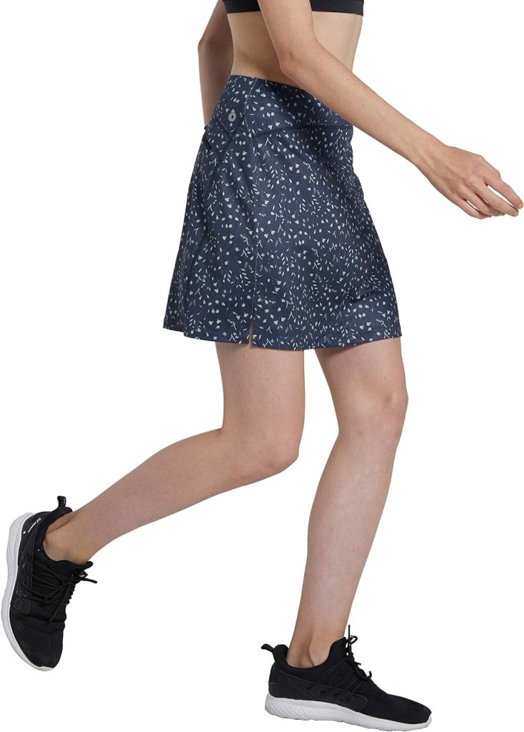 Laad afbeelding in Galerijviewer, Een persoon rent in een ‘Sportieve en stijlvolle golfskort voor dames’, gecombineerd met een zwarte sportbeha en strakke zwarte sneakers, tegen een witte achtergrond.
