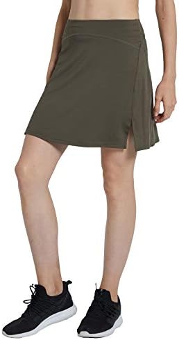 Laad afbeelding in Galerijviewer, Een persoon die de modieuze Sportieve en Stijlvolle golfskort voor dames draagt in olijfgroen met zijsplit en zwarte sneakers, laat stijl en functionaliteit perfect zien in geweven sportkleding.
