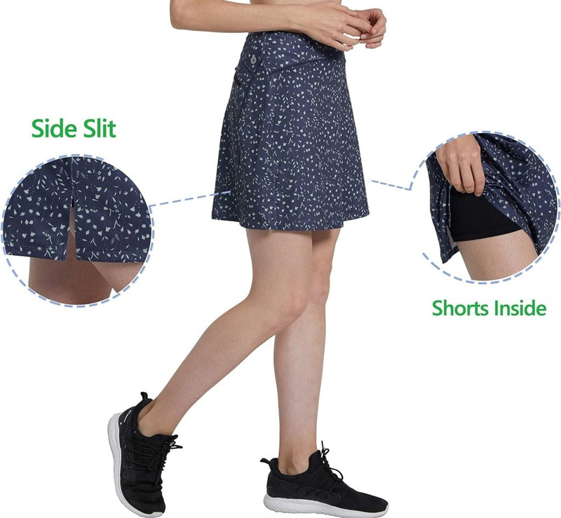 Laad afbeelding in Galerijviewer, Een vrouw, in zijaanzicht, modelleert een rok met marineblauw patroon, een zijsplit en een ingebouwde zwarte korte broek - perfect als de &quot;Sportieve en stijlvolle golfskort voor dames&quot; - terwijl ze zwarte sneakers draagt. Het ensemble benadrukt stijlvolle damessportkleding gemaakt van geweven materiaal.
