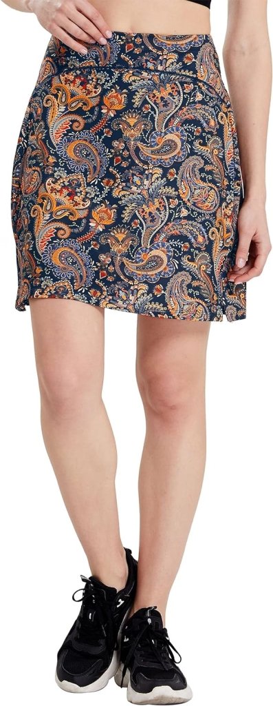 Laad afbeelding in Galerijviewer, Een persoon in een donkerblauwe &#39;Sportieve en stijlvolle golfskort voor dames&#39; met paisley-patroon en zwarte sneakers staat tegen een witte achtergrond, wat stijlvolle damessportkleding benadrukt.

