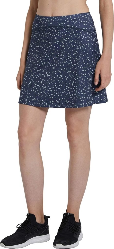 Laad afbeelding in Galerijviewer, Een persoon draagt een stijlvolle &#39;Sportieve en stijlvolle golfskort voor dames&#39; met blauw patroon, gecombineerd met strakke zwarte sneakers, weergegeven vanaf de taille tot aan de voeten.
