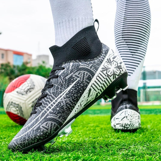 Close-up van iemand die ⚽ Domineer het veld met deze high-performance voetbalschoenen! draagt in zwart en wit, met een hoog ontwerp op gras met een rood-witte voetbal, die stijl combineert met grip en stabiliteit voor topprestaties.