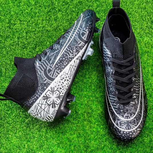 De ⚽ Domineer het veld met deze hoogwaardige voetbalschoenen! zijn zwart en grijs met ingewikkelde patronen, met een hoog ontwerp voor verbeterde grip en stabiliteit, geplaatst op groen kunstgras.