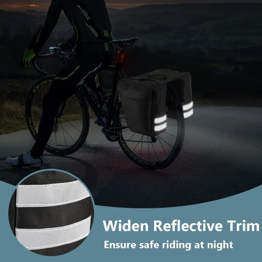 Een fietser rijdt 's nachts met de Fietstassen 28L - Waterdichte fietszadeltas, voorzien van reflecterende details voor verbeterde zichtbaarheid en zorgt voor veilig fietsen door de "Widen Reflective Trim" tekst.