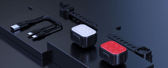 De "Heldere oplaadbare fietsverlichting voor veiligheid in donkere omstandigheden" omvat twee oplaadbare LED-fietslampen (een witte en een rode) met USB-oplaadkabels en bevestigingsriemen. Gepresenteerd op een zwart oppervlak, wordt hun strakke ontwerp prominent weergegeven.