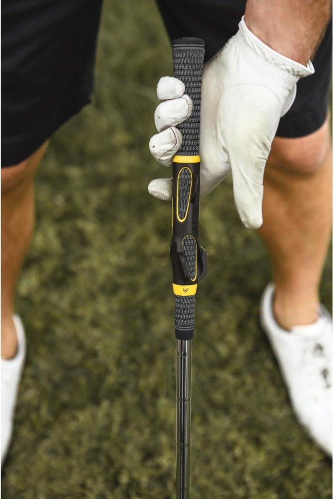 Laad afbeelding in Galerijviewer, Een persoon met een witte handschoen pakt de zwart-gele handgreep van de Perfecte grip met de golfvliegtrainer vast op een weelderig groen veld, waardoor de swing wordt verfijnd en het spiergeheugen van toegewijde golfers wordt verbeterd.
