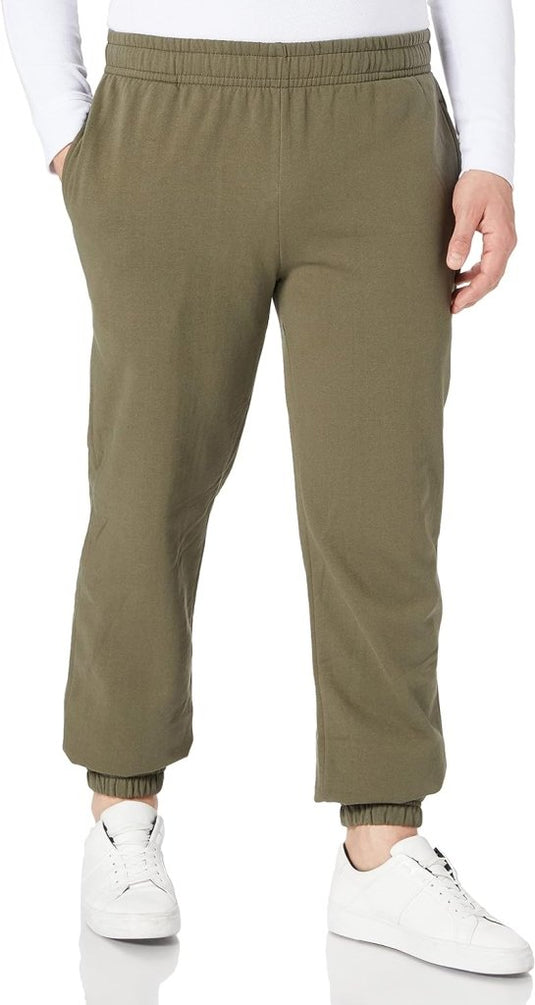 Gekleed in de Comfortabele en stijlvolle heren joggingbroek, een dagelijkse essential, met witte sneakers tegen een effen witte achtergrond, straalt een persoon stijl en comfort uit terwijl ze met hun handen in hun zakken staan.