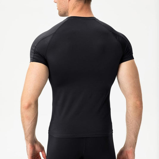 Persoon die in het zwart "Verbeter je prestaties met dit vaste compressieshirt voor heren" draagt, wegkijkend tegen een neutrale achtergrond.