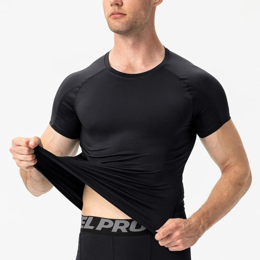 Een man in een zwart T-shirt tilt het op en onthult zwart merkondergoed, waarmee hij zijn "Verbeter je prestaties met dit waardige compressieshirt voor heren" voor optimaal spierherstel laat zien.