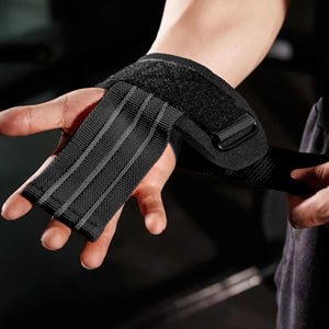Close-up van een hand met de Stevige-hefriemen voor maximale kracht en ondersteuning. Gemaakt van zwarte stof met klittenbandsluitingen en grijze lijnen, ideaal voor krachttraining.