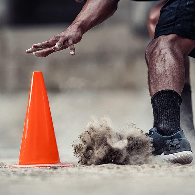 Load image into Gallery viewer, Een atleet in sneakers en zwarte sokken rent langs een trainingskegel en doet stof opwaaien tijdens de voetbaltraining met onze premium trainingskegels.
