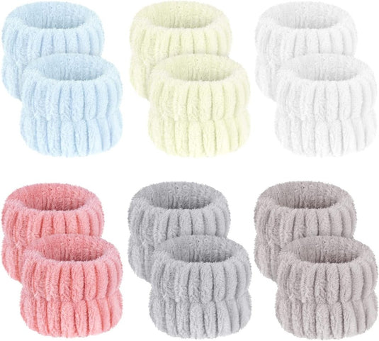 Een set van 12 geribbelde haarbanden gemaakt van microvezelmateriaal in lichtblauw, lichtgeel, wit, roze en grijs. Deze elastische polsbanden voor gezichtsverzorging zijn perfect voor yoga en make-up of als zachte spa-armbanden.