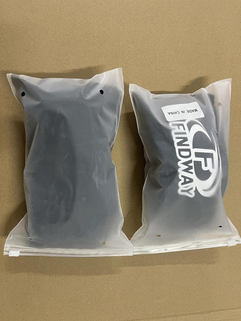 Laad afbeelding in Galerijviewer, Twee zwarte artikelen in een doorzichtige verpakking bevinden zich op een bruine ondergrond. Op één verpakking staat het logo &quot;FINDWAY&quot; en &quot;MADE IN CHINA&quot;, met een skibril met dubbele anti-mist lens en UV-bescherming, bekend als &quot;Skibril met UV-bescherming en anti-mist coating – Helder zicht voor elke wintersport.
