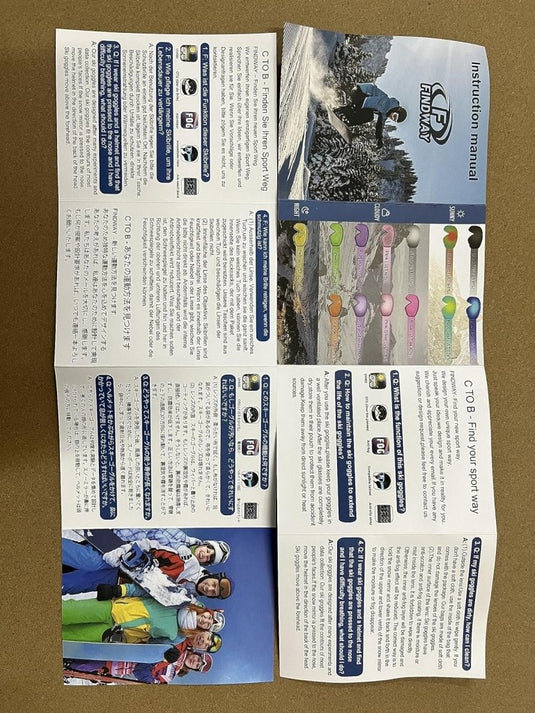 Een opengeslagen handleiding toont felgekleurde skistokken en mensen met skiuitrusting, voorzien van een skibril met UV-bescherming en anti-mist coating, die voor een helder zicht op de piste zorgt, met tekst in het Engels en Japans.