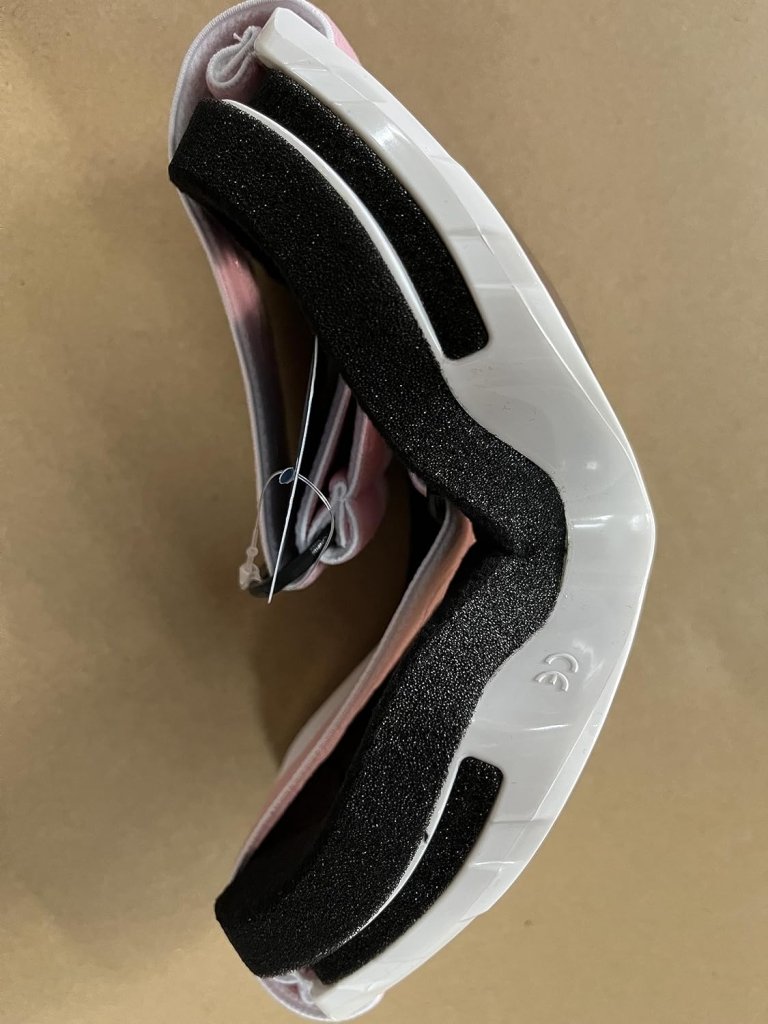 Laad afbeelding in Galerijviewer, Een paar omgekeerde inline skatewielen met zwarte demping en een witte onderkant, op een beige oppervlak, wat doet denken aan het strakke design van de Skibril met UV-bescherming en anti-condens coating voor helder zicht tijdens de wintersport.
