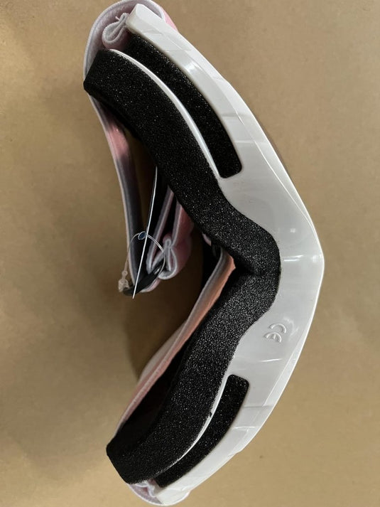 Een paar omgekeerde inline skatewielen met zwarte demping en een witte onderkant, op een beige oppervlak, wat doet denken aan het strakke design van de Skibril met UV-bescherming en anti-condens coating voor helder zicht tijdens de wintersport.