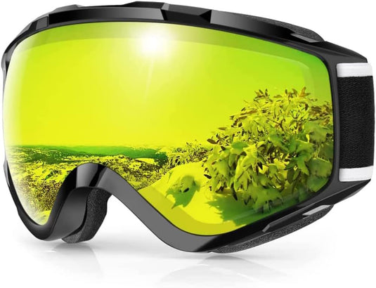 Zwarte skibril met geel getinte lenzen weerspiegelt een besneeuwd landschap en groen gebladerte, met dubbele anti-mist lens voor helder zicht en UV-bescherming. Product: Skibril met UV-bescherming en anti-mist coating – Helder zicht voor elke wintersport.