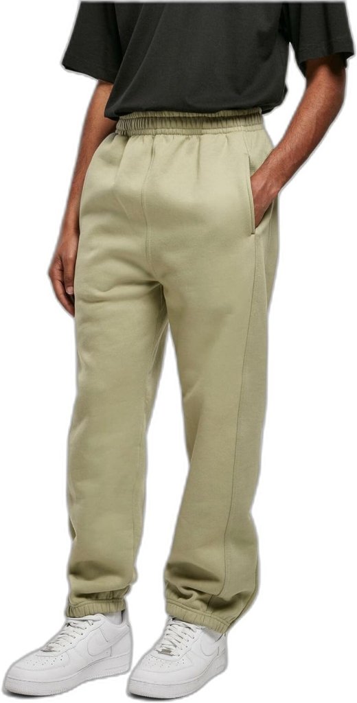 Laad afbeelding in Galerijviewer, Een persoon die een olijfgroene &#39;Comfortabele en stijlvolle joggingbroek voor heren&#39; draagt, een zwart shirt en witte sneakers, staande tegen een witte achtergrond.
