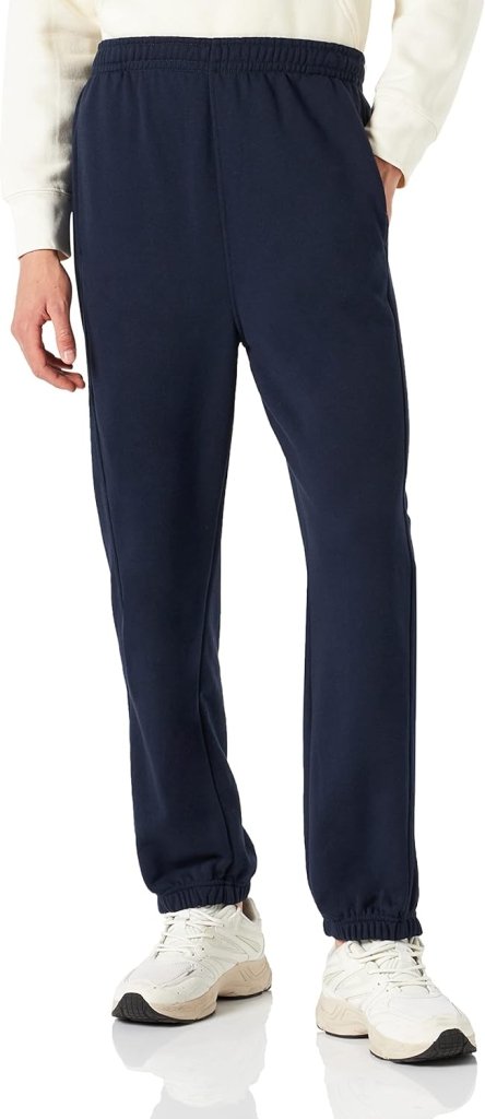 Laad afbeelding in Galerijviewer, Een persoon in een wit sweatshirt en een marineblauwe &quot;Comfortabele en stijlvolle joggingbroek voor heren&quot;, gecombineerd met witte sneakers, staat tegen een effen achtergrond.
