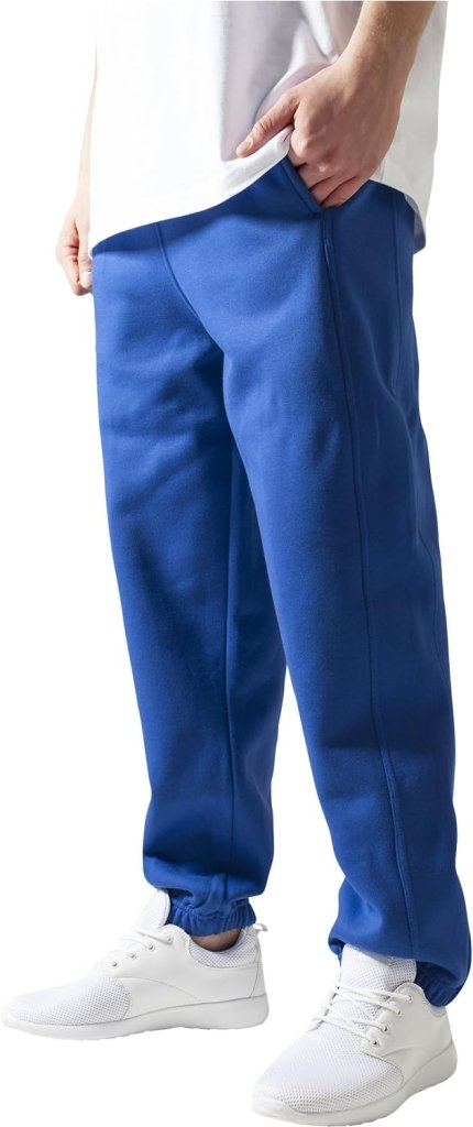 Laad afbeelding in Galerijviewer, Een persoon in een comfortabele en stijlvolle blauwe joggingbroek voor heren, een wit overhemd en witte sneakers staat met zijn handen langs zijn lichaam.
