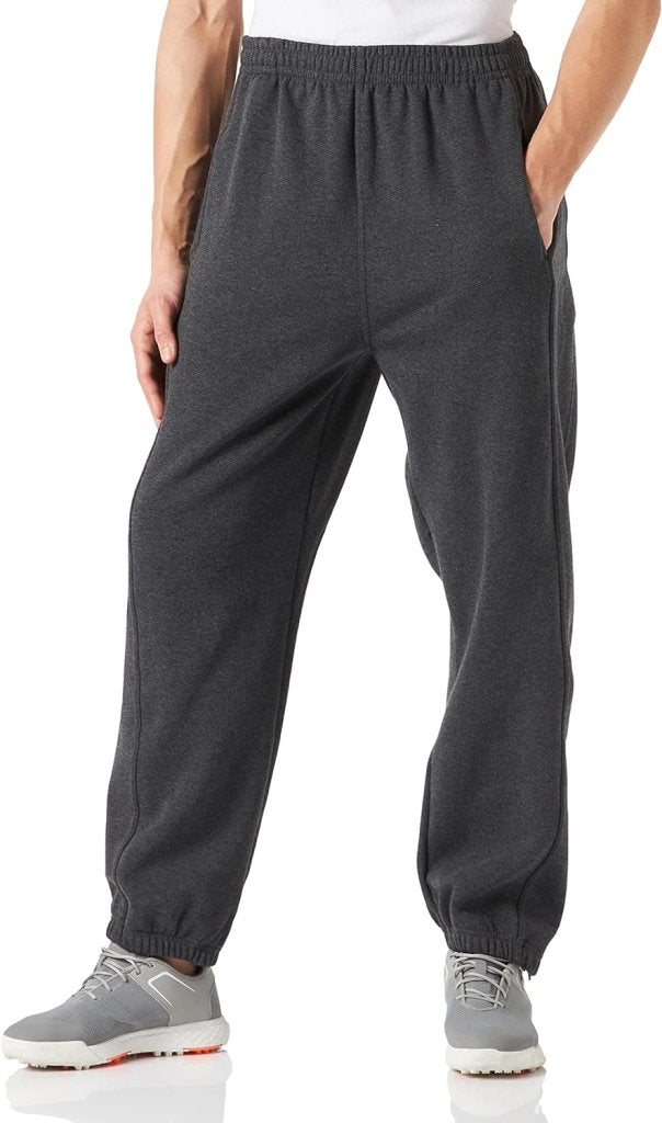 Laad afbeelding in Galerijviewer, Een persoon in een comfortabele en stijlvolle joggingbroek voor heren en grijze sneakers staat met de handen in de zakken, naar voren gericht.
