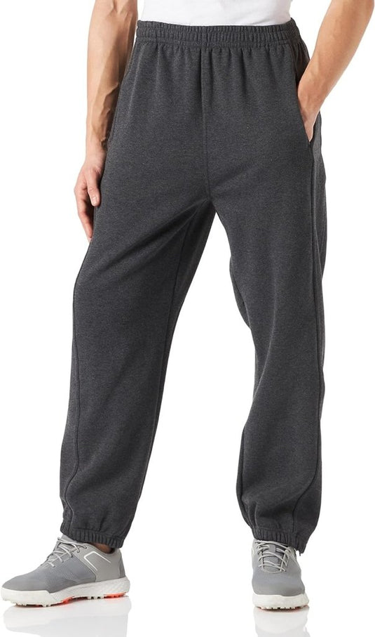 Een persoon in een comfortabele en stijlvolle joggingbroek voor heren en grijze sneakers staat met de handen in de zakken, naar voren gericht.