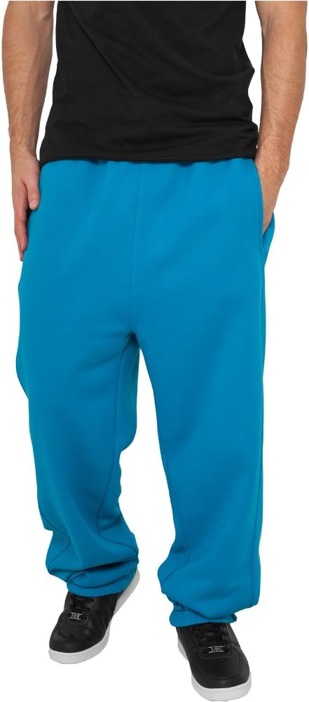 Laad afbeelding in Galerijviewer, Een persoon draagt een zwart overhemd, felblauwe &quot;Comfortabele en stijlvolle joggingbroek voor heren&quot;, en zwarte sneakers met witte zolen, staand met de handen in de zakken.

