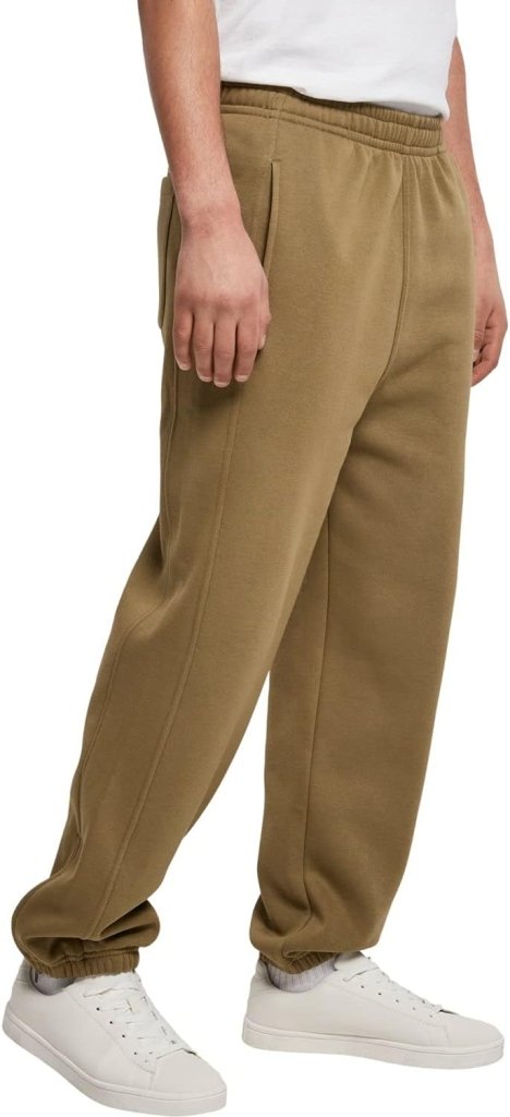 Laad afbeelding in Galerijviewer, Een persoon in beige Comfortabele en stijlvolle joggingbroek voor heren en witte sneakers, zijwaarts staand. De elastische manchetten van de broek worden gecombineerd met een fris wit overhemd dat de nonchalante, slanke snit versterkt.
