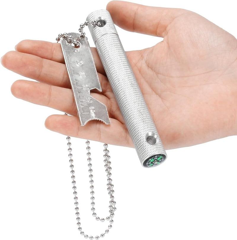 Load image into Gallery viewer, Een hand die de Robuuste vuurstarter vasthoudt, met een liniaal, ketting, kompas en cilindervormig handvat, ideaal voor elk buitenavontuur.
