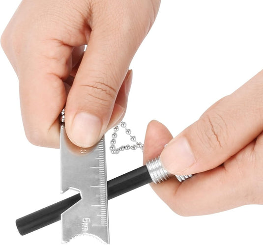 Handen grijpen een Robuuste vuurstarter, uitgerust met een metalen gereedschap, liniaal en flesopener. Ze passen een zwarte zaklamp aan, ter voorbereiding op een avontuur in de buitenlucht.