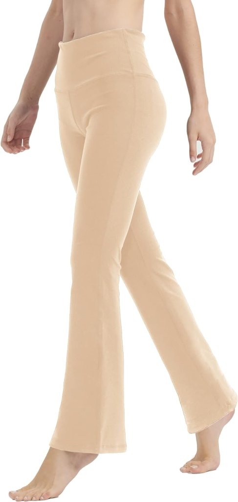 Op de foto is iemand te zien die op blote voeten loopt in een beige Yoga broek voor vrouwen: Perfecte buikcontrole en comfort, met een uitlopend design dat vrijheid uitstraalt tegen een witte achtergrond, waarbij alleen de onderste helft van het lichaam zichtbaar is.