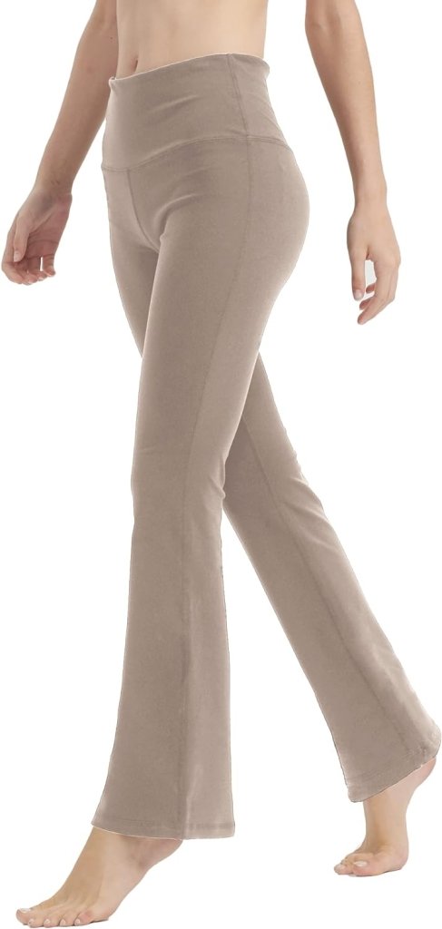 Een persoon staat tegen een witte achtergrond en draagt een yogabroek voor vrouwen met perfecte buikcontrole en comfort.