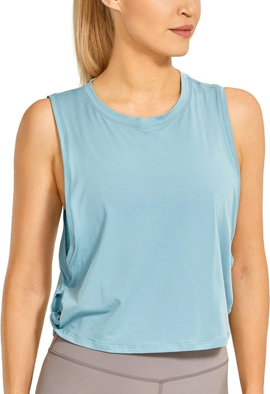 Een persoon in een "Stijlvol en comfortabel: Yoga dames pima cotton workout tank crop" en grijze legging kijkt opzij.