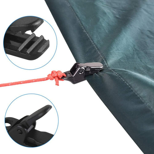 Close-up van het zeil vastgehouden door een zwarte tentclip bevestigd aan een rood touw, ideaal voor kamperen. Inzetstukken bieden gedetailleerde weergaven van het grijpmechanisme van de clip. Verbeter uw outdooravontuur met deze set van 100 zwarte tentclips!.