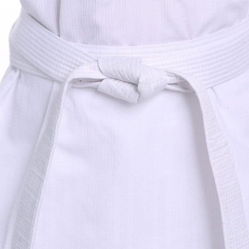 Laad afbeelding in Galerijviewer, Een close-up van een wit karatepak laat de riem zien, een &quot;Elevateer je training met onze premium judo/karate banden&quot;, die netjes in een knoop om de taille zit.
