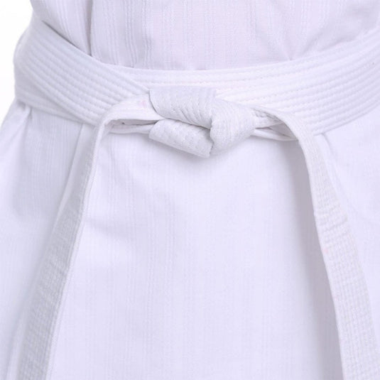 Een close-up van een wit karatepak laat de riem zien, een "Elevateer je training met onze premium judo/karate banden", die netjes in een knoop om de taille zit.