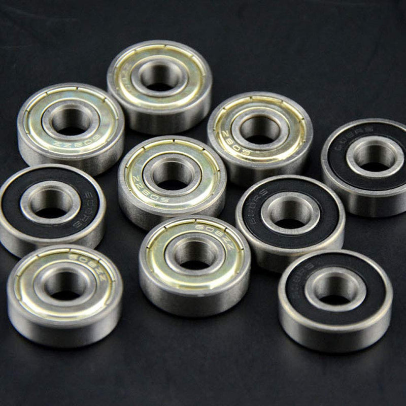 Laad afbeelding in Galerijviewer, Tien metalen skateboardkogellagers op een donker oppervlak, met verschillende afdichtingen met metalen schilden en zwart rubber voor optimale skateprestaties, afkomstig uit onze hoogwaardige 30-delige lagerset.
