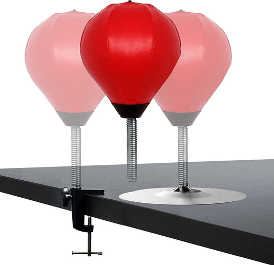 Drie veelzijdige Ontdek stressvermindering boksballen - twee rood, één gedeeltelijk transparant - zijn perfect om stress te verminderen. Vastgeklemd aan een donker tafelblad, helpen ze de hand-oogcoördinatie te verbeteren.